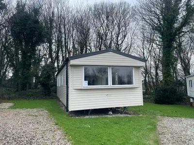 a small shed with a window in a yard at 26 The Green Captains Cabin in Crantock