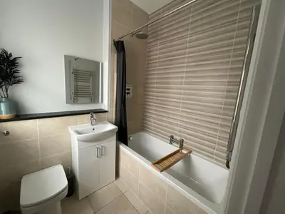 a bathroom with a tub and a toilet and a sink at 8, St Marys ,Central Truro Apartment, Long Stay Ready, 2 Bed 2 Bath in Truro