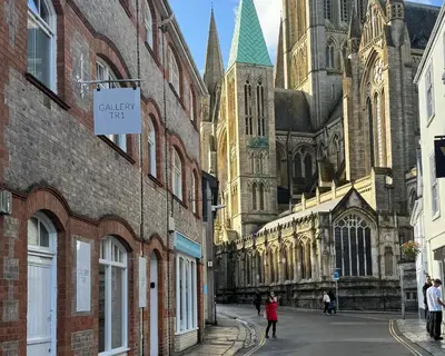 a woman walking down a street in front of a cathedral at 8, St Marys ,Central Truro Apartment, Long Stay Ready, 2 Bed 2 Bath in Truro