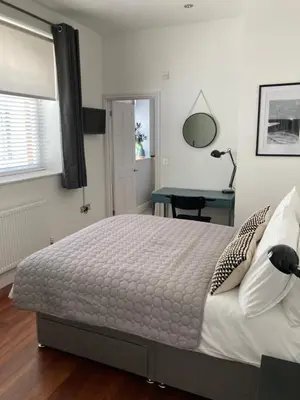 a bedroom with a large bed and a desk at 8, St Marys ,Central Truro Apartment, Long Stay Ready, 2 Bed 2 Bath in Truro