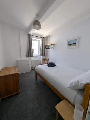 a bedroom with a large bed and a window at The Old Corner Shop - Wellington Terrace in Falmouth