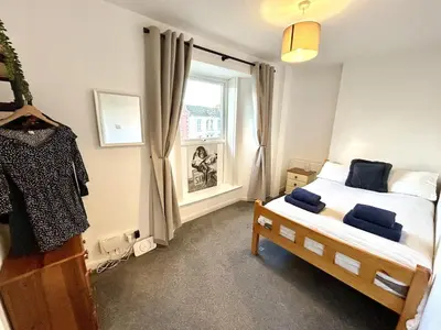 a small bedroom with a bed and a window at The Old Corner Shop - Wellington Terrace in Falmouth