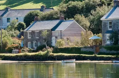 a house and a boat in the water next to a house at Holly in Kea