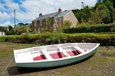a white boat sitting on the grass in front of a house at Holly in Kea