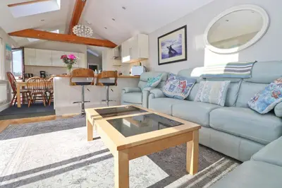 a living room with a blue couch and a table at Sea View House in Newquay