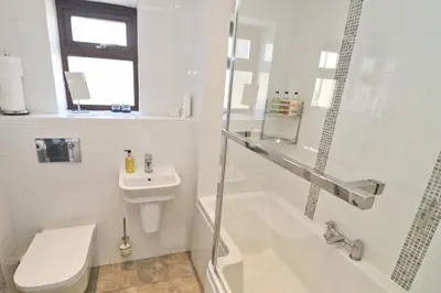 a white bathroom with a toilet and a sink at Sea View House in Newquay