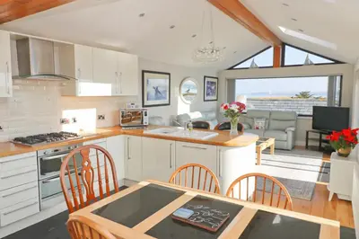 a kitchen and living room with a table and chairs at Sea View House in Newquay