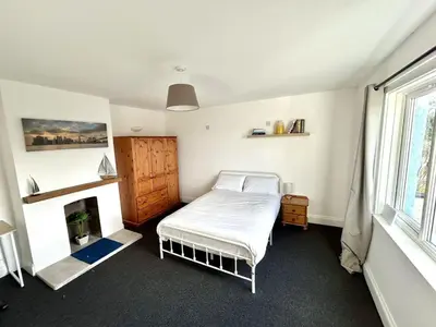 a bedroom with a bed and a fireplace at The Blue House - Godolphin - Large Spacious Home in Falmouth