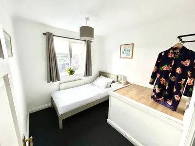 a small bedroom with a bed and a window at The Blue House - Godolphin - Large Spacious Home in Falmouth