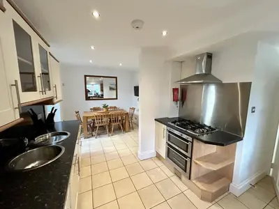 a kitchen with a sink and a stove top oven at The Blue House - Godolphin - Large Spacious Home in Falmouth