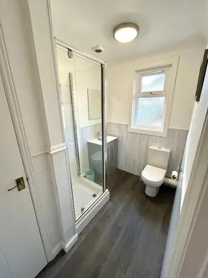 a bathroom with a toilet and a glass shower at The Blue House - Godolphin - Large Spacious Home in Falmouth
