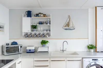 a white kitchen with a sink and a microwave at Sealight Cottage in St Ives