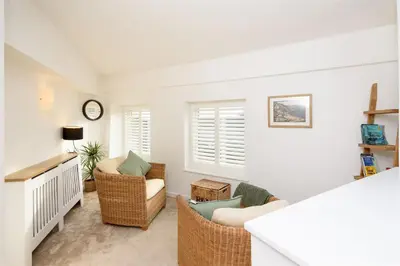 a living room with two chairs and a couch at Custom House - Modern town centre house, sea views, two minutes to the beach in Looe