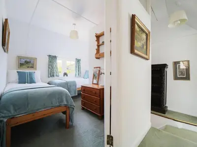 a bedroom with two beds and a fireplace at Rose Hill Cottage in Port Isaac