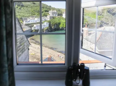 a view of a beach from a window at Rose Hill Cottage in Port Isaac