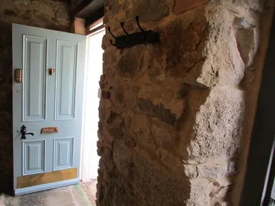 a door in a stone wall next to a stone wall at Cornwall Log Burner no cleaning fee in Camborne