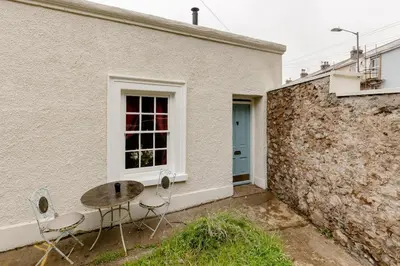 a table and chairs in front of a building at Cornwall Log Burner no cleaning fee in Camborne