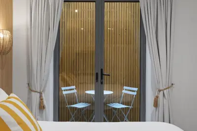 a bedroom with a table and two chairs through a glass door at Groundfloor Apartment Opposite Beach with Parking in Newquay