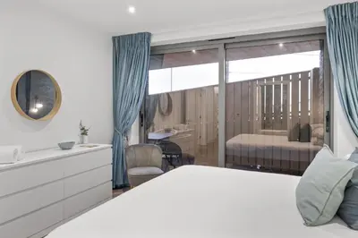 a bedroom with a large bed and a bathroom at Groundfloor Apartment Opposite Beach with Parking in Newquay