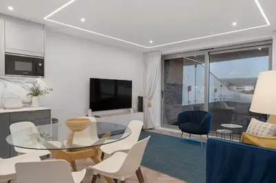 a living room with a glass table and white chairs at Modern Groundfloor Apartment with Private Parking in Newquay