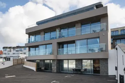 an apartment building with large glass windows at Modern Groundfloor Apartment with Private Parking in Newquay