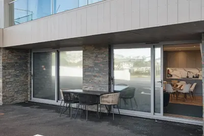 a table and chairs sitting outside of a building at Modern Groundfloor Apartment with Private Parking in Newquay