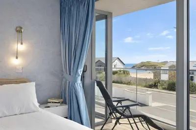 a bedroom with a bed and a view of the ocean at Modern Apartment with Balcony Sea Views & Parking in Newquay