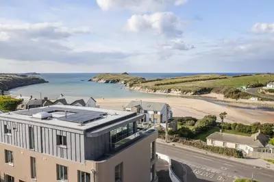a building with a view of a beach and the ocean at Modern Apartment with Balcony Sea Views & Parking in Newquay