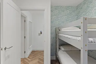 a small room with a bunk bed and a hallway at Modern Apartment Opposite Beach Parking & Balcony in Newquay