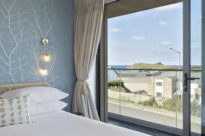 a bedroom with a bed and a view of the ocean at Luxurious Apartment Balcony & Sea Views Parking in Newquay