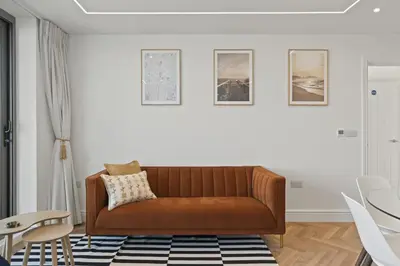 a living room with a brown couch and a table at Luxurious Apartment Balcony & Sea Views Parking in Newquay
