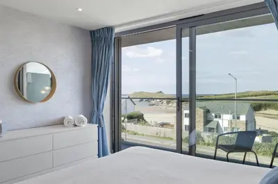 a bedroom with a large window with a view of the ocean at Apartment Balcony with Expansive Sea Views Parking in Newquay