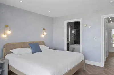 a bedroom with a large white bed with a blue pillow at Apartment Balcony with Expansive Sea Views Parking in Newquay