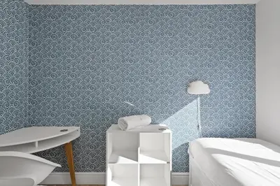 a bedroom with blue wallpaper and a bed and a table at Apartment Balcony with Expansive Sea Views Parking in Newquay