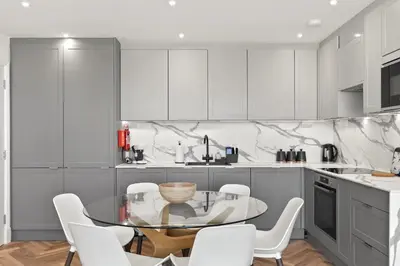 a kitchen with a glass table and white chairs at Apartment Balcony with Expansive Sea Views Parking in Newquay