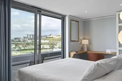 a hotel room with a bed and a large window at Penthouse Balcony with Expansive Sea Views Parking in Newquay
