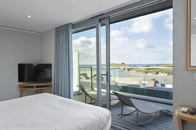 a bedroom with a bed and a view of the ocean at Penthouse Balcony with Expansive Sea Views Parking in Newquay