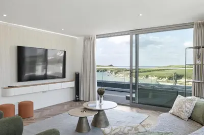 a living room with a tv and a large window at Penthouse Balcony with Expansive Sea Views Parking in Newquay