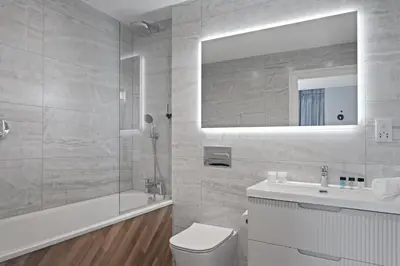 a bathroom with a toilet and a sink and a mirror at Penthouse Balcony with Expansive Sea Views Parking in Newquay