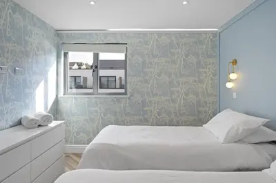 a bedroom with a white bed and a window at Penthouse Balcony with Expansive Sea Views Parking in Newquay