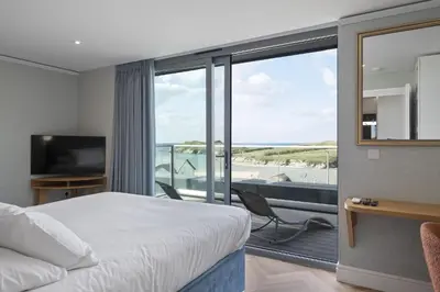 a bedroom with a bed and a balcony with a view at Penthouse Balcony with Expansive Sea Views Parking in Newquay