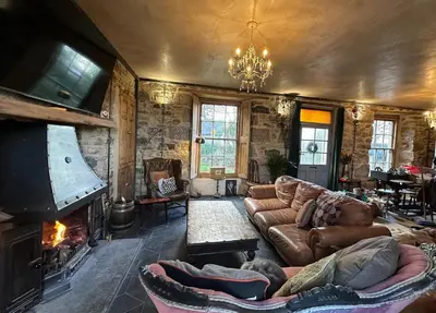 a living room with a couch and a fireplace at Tin Miners Captain Georgian hs, parking, Logburner in Camborne