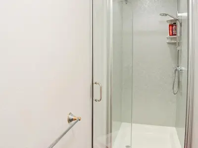 a shower with a glass door in a bathroom at Little Content Farm Cottage in Cury