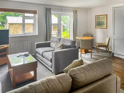 a living room with a couch and a table at Spruce Cottage in Tywardreath