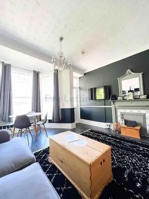 a living room with a couch and a table at Modern classic seaside apartment with parking and balcony in St Ives