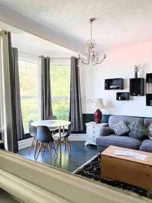 a living room with a couch and a table at Modern classic seaside apartment with parking and balcony in St Ives