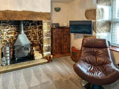 a leather chair in a living room with a fireplace at Number 8 in Camborne