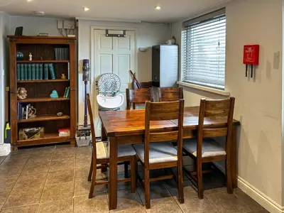 a dining room with a wooden table and chairs at Number 8 in Camborne