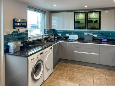 a kitchen with a washing machine and a sink at Number 8 in Camborne