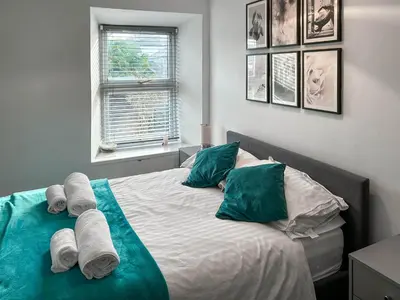 a bedroom with a bed with towels on it at Number 8 in Camborne
